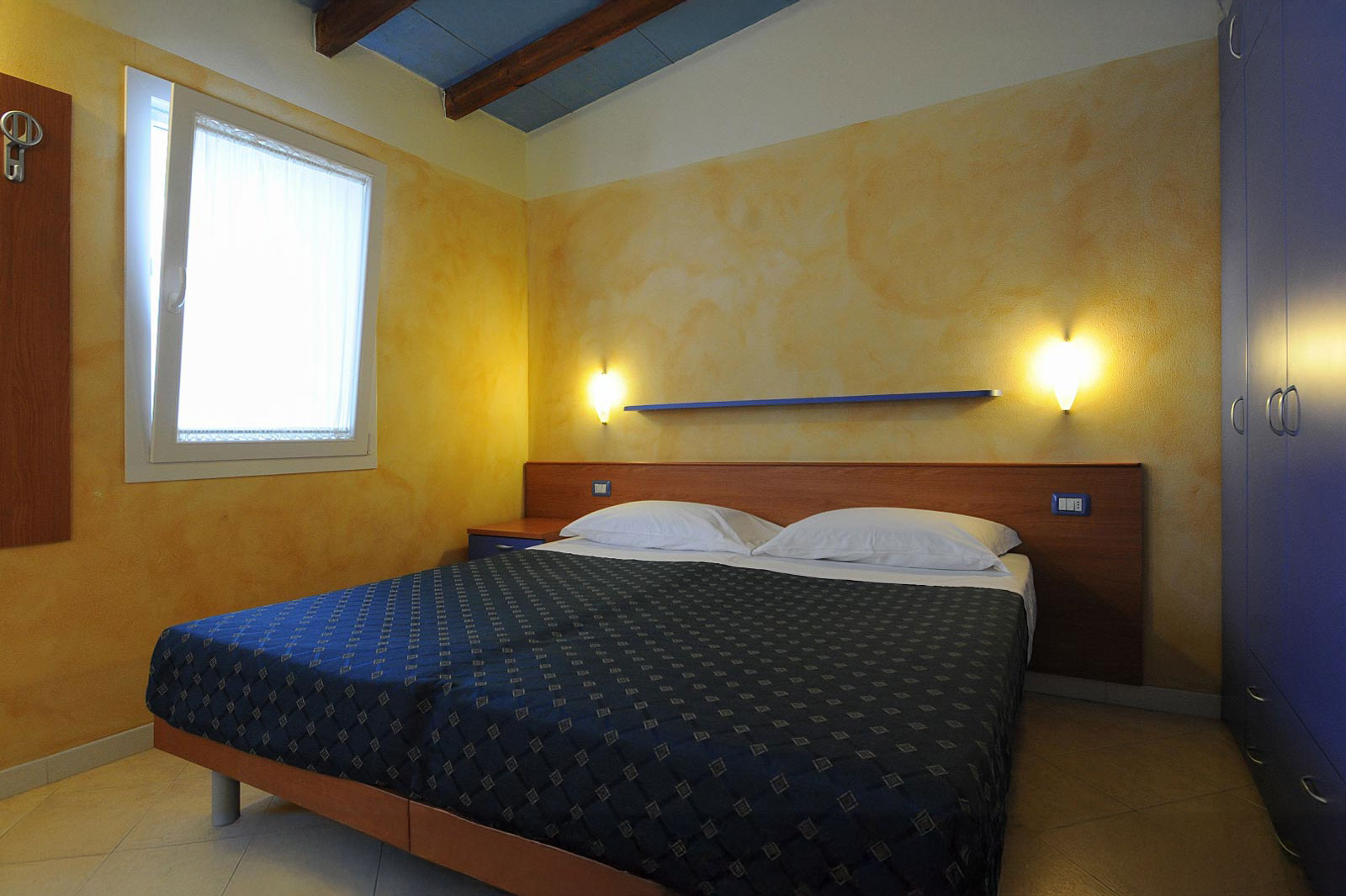 Camera matrimoniale del Bungalow Mare al Park Gallanti con letto matrimoniale, finestra e armadio
