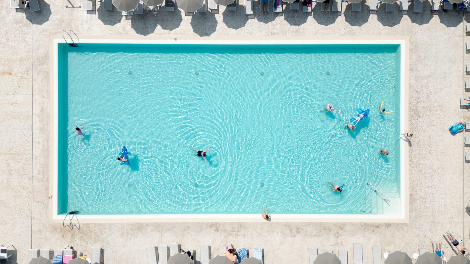 Luftaufnahme des Hauptpools im Park Gallanti Holiday Village mit Sonnenschirmen und Badegästen.